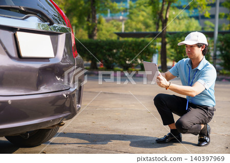 Insurance agent inspecting car damage after accident 140397969
