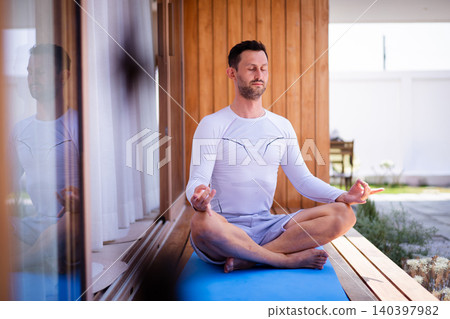 Calm man sitting in lotus position for mindfulness and relaxation Calm man sitting in lotus position for mindfulness and relaxation 140397982