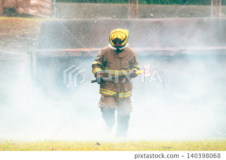 Firefighter running with an axe during emergency training exercise Firefighter running with an axe during emergency training exercise 140398068