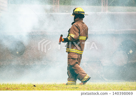 Firefighter running with an axe during emergency training exercise 140398069