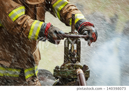 Firefighter Hands Turning Water Valve in Action Firefighter Hands Turning Water Valve in Action 140398073