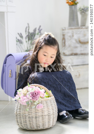 A Japanese girl with a schoolbag on her back gazes at a basket of flowers. A Japanese girl with a schoolbag on her back gazes at a basket of flowers. 140398077