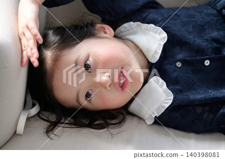 A Japanese girl relaxing on a sofa. A Japanese girl relaxing on a sofa. 140398081