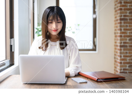 Young businesswoman using laptop in office 140398104