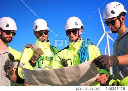 Engineers discussing a blueprint plan at a wind turbine farm Engineers discussing a blueprint plan at a wind turbine farm 140398426