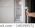 Opening an Empty Refrigerator at Home Before Grocery Shopping 140399572
