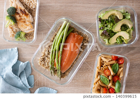 Healthy meal prep containers with salmon, chicken, pasta and fresh vegetables 140399615