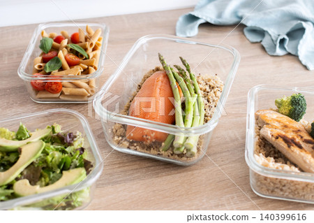 Healthy meal prep containers with salmon, chicken, pasta and fresh vegetables 140399616