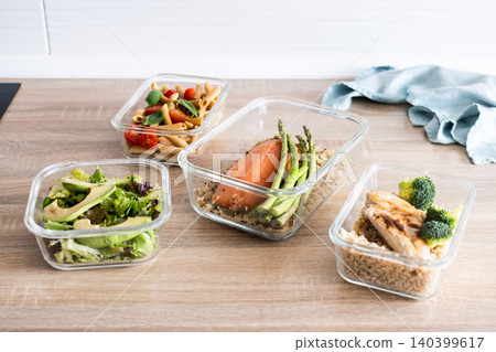 Healthy meal prep containers with salmon, chicken, pasta and fresh vegetables 140399617