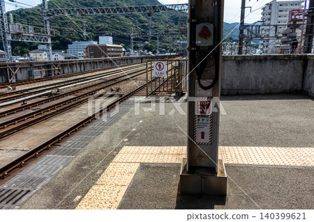 車站月台上的列車緊急停車按鈕和鐵軌景色。 車站月台上的列車緊急停車按鈕和鐵軌景色。 140399621