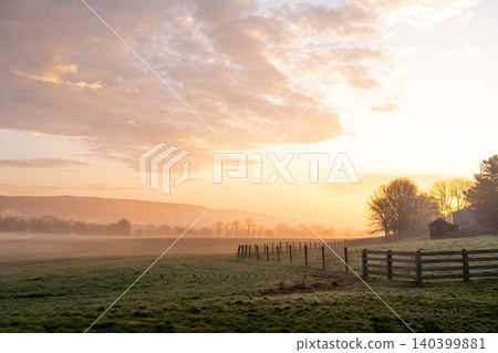 Misty Golden Sunrise Over Frost-Covered Rural Pasture Misty Golden Sunrise Over Frost-Covered Rural Pasture 140399881