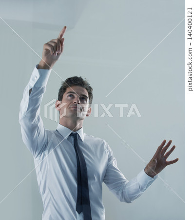 Future, interface and business man user in studio on gray background for touchscreen biometrics. Internet, tech or virtual and young employee pointing to access database or metaverse information Future, interface and business man user in studio on gray background for touchscreen biometrics. Internet, tech or virtual and young employee pointing to access database or metaverse information 140400121