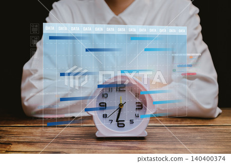 Business planning concept. Professional analysis of time management with data visualization alongside a vintage clock on wooden table background Business planning concept. Professional analysis of time management with data visualization alongside a vintage clock on wooden table background 140400374