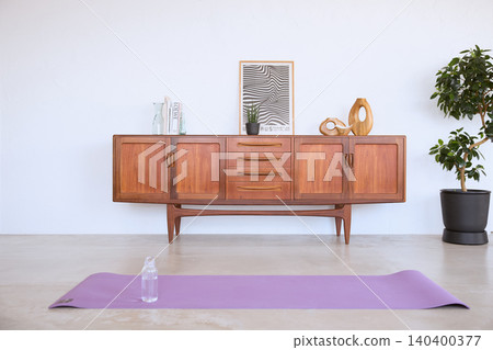 A stylish living room with a Scandinavian vintage sideboard and a yoga mat. 140400377