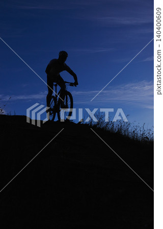 Cyclist, silhouette and bicycle ride at night, hill and mountain biking in countryside. Person, freedom and sky mockup for fitness or exercise, hobby and sports for outdoor adventure and cycling 140400609