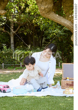 A mother and her young son enjoying a picnic in the park A mother and her young son enjoying a picnic in the park 140400897