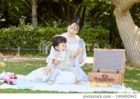 一位母親和她的小兒子在公園野餐 一位母親和她的小兒子在公園野餐 140400943