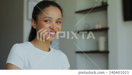 Portrait of a sporty woman looking at the camera resting after training at home. Beautiful healthy sportive girl athlete resting after intense hard training. 140401023