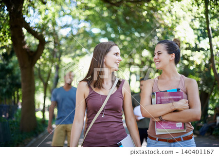 Women, friends and talking of education on campus with learning, knowledge and books at college. Happy students with outdoor conversation in a park or university for scholarship, study or opportunity 140401167