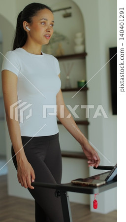 Vertical video. Workout, woman and walking on treadmill in home for cardio exercise, fitness challenge and burning calories. Vertical video. Workout, woman and walking on treadmill in home for cardio exercise, fitness challenge and burning calories. 140401291