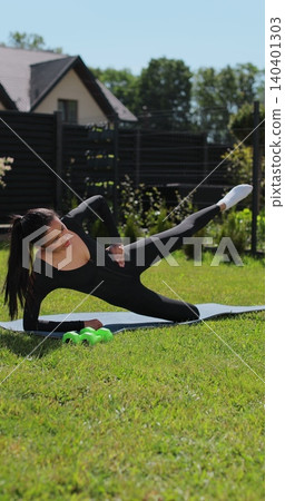 Vertical video. Young woman doing sports at nature, Female fitness training in sportswear. Sport, fitness, health and lifestyle concept. Vertical video. Young woman doing sports at nature, Female fitness training in sportswear. Sport, fitness, health and lifestyle concept. 140401303