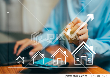 Businessperson Analyzing Housing Market Trends with Graphs and Home Icons on Tabletop, Business concept. Businessperson Analyzing Housing Market Trends with Graphs and Home Icons on Tabletop, Business concept. 140401325