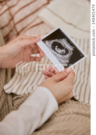 A pregnant woman holding an ultrasound image A pregnant woman holding an ultrasound image 140401474