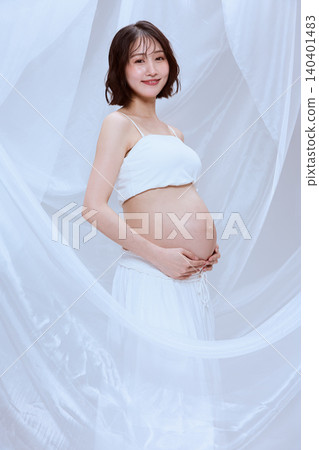A pregnant woman wrapped in white cloth; a peaceful image of maternity. A pregnant woman wrapped in white cloth; a peaceful image of maternity. 140401483