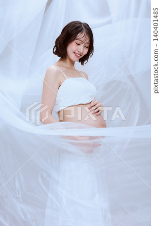 A pregnant woman wrapped in white cloth; a peaceful image of maternity. 140401485