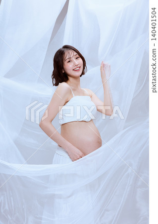 一位孕婦裹著白布，展現了寧靜祥和的孕育景象。 140401504
