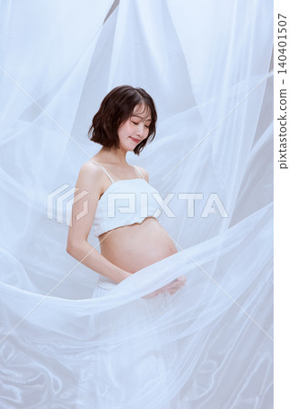 一位孕婦裹著白布,展現了寧靜祥和的孕育景象。 一位孕婦裹著白布,展現了寧靜祥和的孕育景象。 140401507