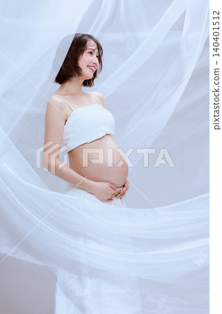 一位孕婦裹著白布,展現了寧靜祥和的孕育景象。 一位孕婦裹著白布,展現了寧靜祥和的孕育景象。 140401512