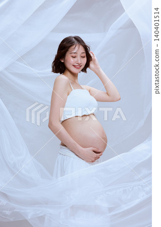 一位孕婦裹著白布，展現了寧靜祥和的孕育景象。 140401514