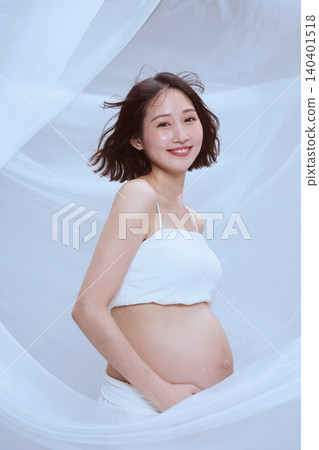 A pregnant woman wrapped in white cloth; a peaceful image of maternity. 140401518