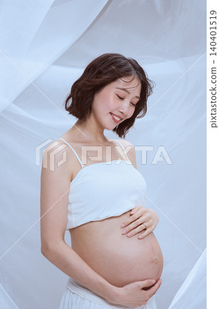一位孕婦裹著白布,展現了寧靜祥和的孕育景象。 一位孕婦裹著白布,展現了寧靜祥和的孕育景象。 140401519