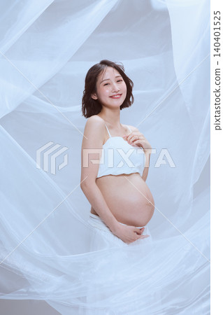 A pregnant woman wrapped in white cloth; a peaceful image of maternity. A pregnant woman wrapped in white cloth; a peaceful image of maternity. 140401525