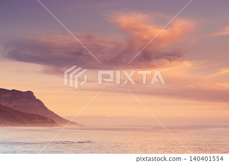Ocean, sunset and calm water by mountain and tourism destination for summer vacation in nature. Blue sky, clouds and neon color on cape town beach, peace and outdoor travel with sunshine in paradise 140401554
