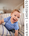 Playing, laughing or portrait of baby in sofa or home for fun, growth or learning alone in living room. Happy, boy or face of a playful male kid on couch for child development or crawling in a house 140401570