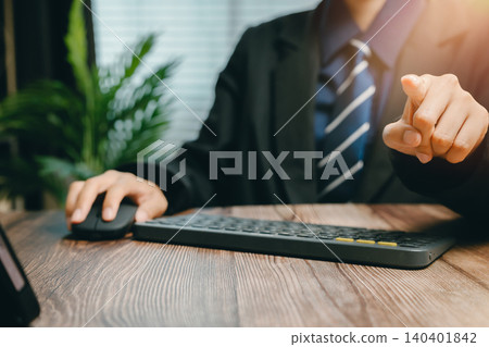 Businessman in Suit Pointing at Computer Screen While Working from Home Office Environment, Business concept Businessman in Suit Pointing at Computer Screen While Working from Home Office Environment, Business concept 140401842