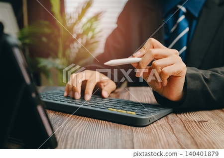 Professional Businessman Working on Laptop with Pen in Hand in Modern Office Environment, Business concept Professional Businessman Working on Laptop with Pen in Hand in Modern Office Environment, Business concept 140401879