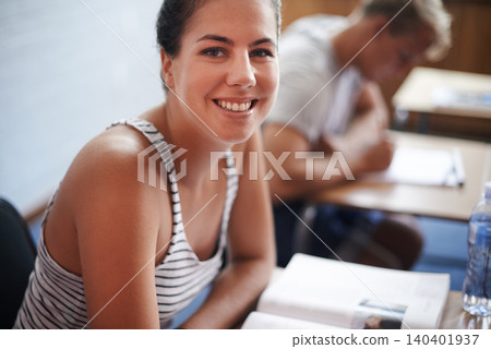 College student, portrait and desk in classroom with books for english literature or language for exam. Female person, university and scholarship for learning or education, knowledge and studying. 140401937