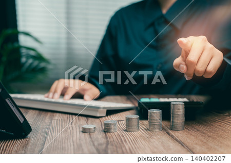 Business Professional Calculating Finances with Coins and Calculator in Modern Office Setting, Business concept Business Professional Calculating Finances with Coins and Calculator in Modern Office Setting, Business concept 140402207