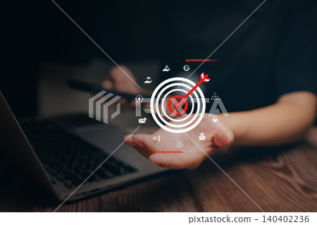 Business target concept. Hand holding smartphone with virtual bullseye target and arrow, goal achievement, digital marketing strategy, performance success and objective planning. 140402236