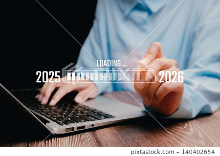 Digital Progress Bar Displaying Transition from 2025 to 2026 with Person Working on Laptop in Modern Office Setting 140402654