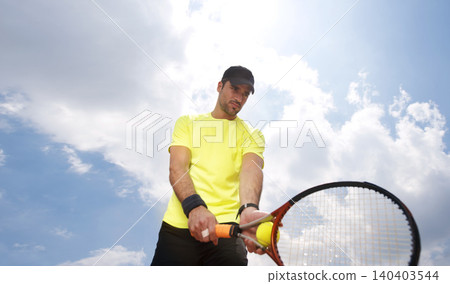 Athlete, serve or racket with tennis ball by blue sky, player or concentration in professional competition. Fitness, outdoor or sportsman in training for tournament or skill of playing hand for shot 140403544