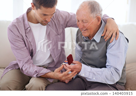 Father, son and medal at home, smile and happy relationship in house. Family bonding, proud dad and child on sofa sitting together, elderly man and giving award at living room after retirement Father, son and medal at home, smile and happy relationship in house. Family bonding, proud dad and child on sofa sitting together, elderly man and giving award at living room after retirement 140403915