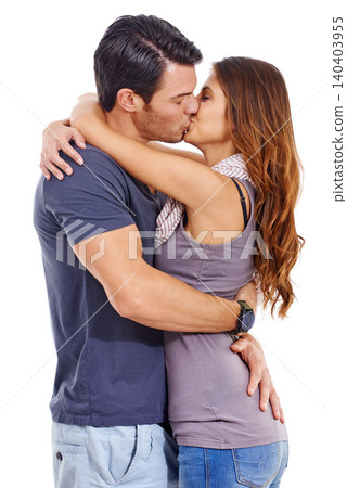 Hug, love and couple kiss in studio for care, romance or commitment to marriage isolated on a white background. Man, woman and touch lips to embrace for connection, support and healthy relationship 140403955