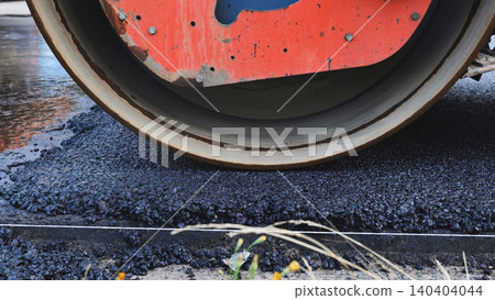 Road roller compacting fresh asphalt during civil engineering construction work 140404044