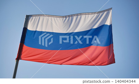 Russian tricolor flag with white, blue, and red stripes flapping in the wind on a sunny day Russian tricolor flag with white, blue, and red stripes flapping in the wind on a sunny day 140404344
