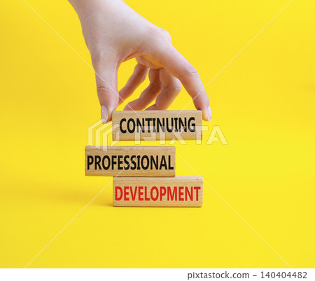 Continuing Development symbol. Concept words Continuing Professional Development on wooden blocks. Businessman hand. Beautiful yellow background. Business and Development concept. Copy space Continuing Development symbol. Concept words Continuing Professional Development on wooden blocks. Businessman hand. Beautiful yellow background. Business and Development concept. Copy space 140404482